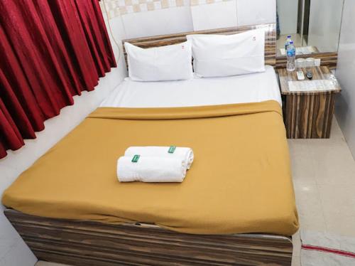 a bed with two towels on it in a room at Shree Residency in Airoli