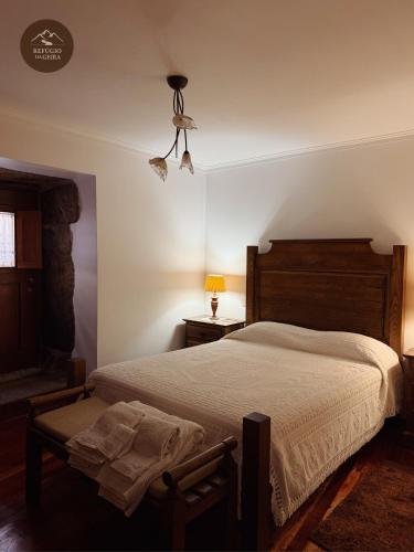 a bedroom with a large bed and a lamp at Refúgio da Geira in Campo do Gerês