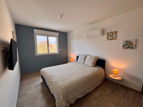 a bedroom with a bed and a window with two lamps at maison 24 couchages in Clermont-Créans