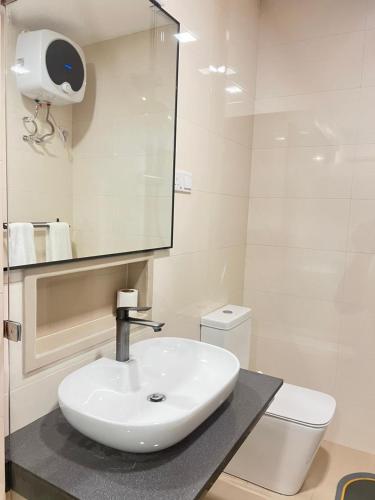 a bathroom with a sink and a toilet and a mirror at REEF VIEW Beach Hotel in Matara