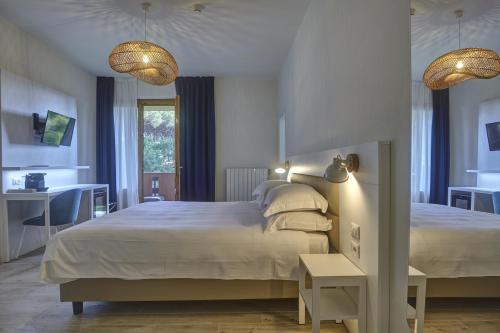 a bedroom with a bed and a desk and two lamps at Dimora Punta Ala in Punta Ala