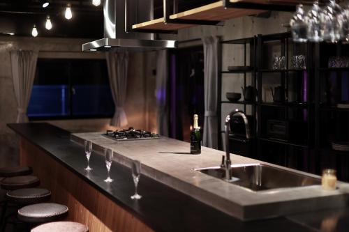 a kitchen counter with a sink and a stove at クリスタルヴィラ大浦 in Miyako-jima