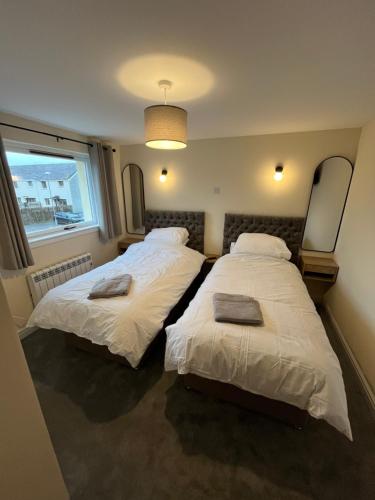 a bedroom with two beds and a window at Caledonian Lock House in Caol
