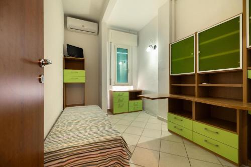 a room with green cabinets and a bed in it at Casa AnnaMarea in San Vincenzo