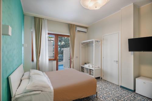 a bedroom with a bed and a television in it at The Reef Sorrento in Sorrento