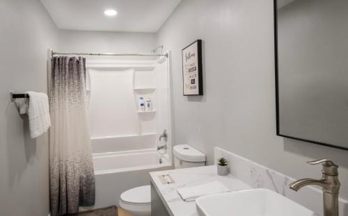 a white bathroom with a toilet and a sink at Gillespie Dr 2BR 1BA Unit A | Near Downtown SD in Spring Valley