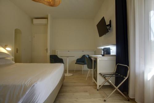 a bedroom with a bed and a table and chairs at Dimora Punta Ala in Punta Ala