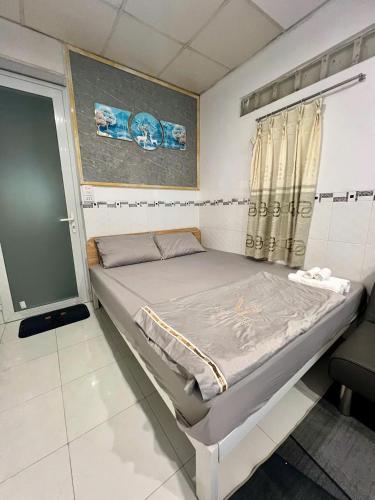 a small bed in a room with a window at Homestay 14 Tôn Đức Thắng in Phan Thiet