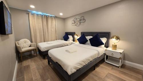 a bedroom with two beds with blue pillows and a chair at Gillespie Dr 2BR 1BA Unit A | Near Downtown SD in Spring Valley