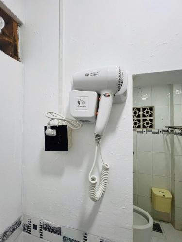 a hairdryer hanging on a wall in a bathroom at Homestay 14 Tôn Đức Thắng in Phan Thiet