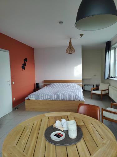 a bedroom with a bed and a wooden table with a table at De Drie Mussen in Diksmuide