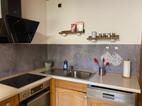 a kitchen with a sink and a stove at Ferienwohnung am Breitenbach in Ebermannstadt