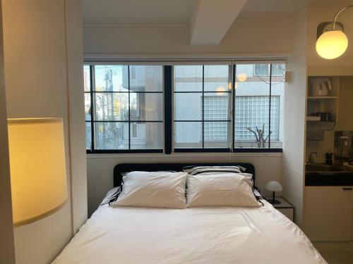 a bedroom with a white bed with a window at Kuro House - In the middle of Hiro, Omotesando, Roppongi in Tokyo