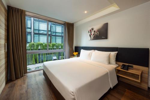 a bedroom with a large bed and a large window at LiT BANGKOK Residence in Bangkok