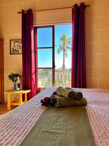 a bedroom with a bed with a palm tree in the window at Ta Carmen Farmhouse with pool in Qala