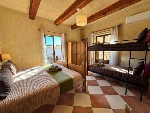 a bedroom with two bunk beds and a checkered floor at Ta Carmen Farmhouse with pool in Qala