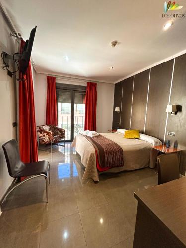 a hotel room with a bedroom with a bed and a desk at HS Alcalá in Alcalá del Júcar