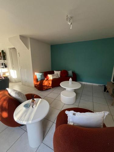 a living room with two tables and a couch at Seaward Cottage met Jacuzzi in De Haan