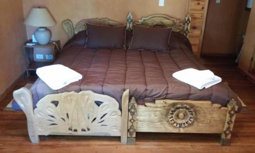 a bed in a room with a wooden bed frame at Finca La Encantada in San Rafael