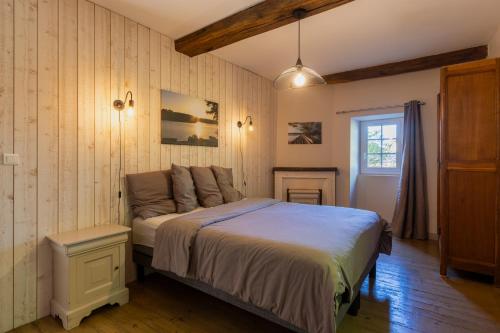 a bedroom with a bed in a room with wooden walls at Montauvert in Montel-de-Gelat
