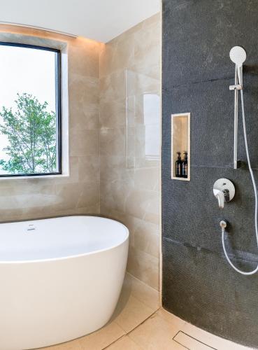 a bathroom with a white tub and a window at Dusit Thani Himalayan Resort Dhulikhel, Nepal in Dhulikhel