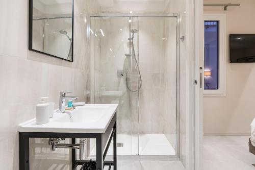 a white bathroom with a shower and a sink at Palazzo Accademia in Florence