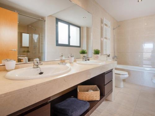 a large bathroom with two sinks and a toilet at R64 Deluxe Villa Déjà Vu in Calafell