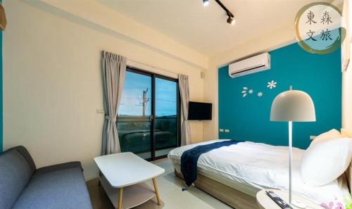 a bedroom with a bed and a couch and a window at 享受一下民宿-免費停車-寵物友善-無門禁24小時進出-東森文旅-包棟優惠中 in Chung-ho