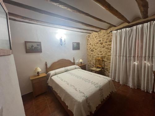 a bedroom with a bed with a white bedspread at Casa Rural Vicenta in Benizar