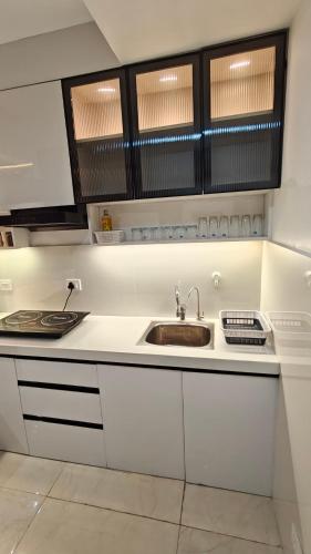 a kitchen with white cabinets and a sink at Anandam in Vrindāvan