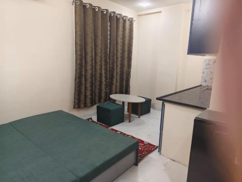 a small room with a bed and a table and a window at Ramashraya in Indore