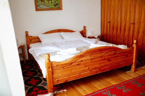 a wooden bed in a bedroom with a red rug at Domaćinstvo Koprivica in Zapolje