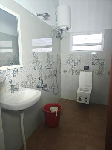 a bathroom with a sink and a toilet at Sanctuary by JVS Palace in Hindupur