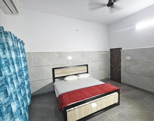 a bedroom with a bed with a red blanket at Sanctuary by JVS Palace in Hindupur