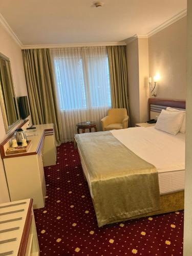 a hotel room with a bed and a desk at Akar International Hotel in Ankara