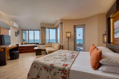 a bedroom with a bed and a living room at Limak Lara Deluxe Hotel & Resort Antalya in Lara