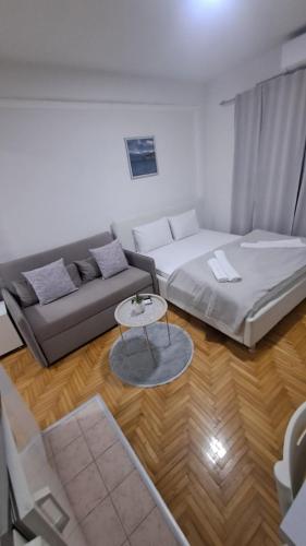 een woonkamer met twee bedden en een bank bij Top Spot Studio in Ohrid