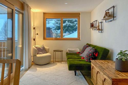 a living room with a green couch and a chair at Gommer Sunna - Joderestutz in Reckingen - Gluringen