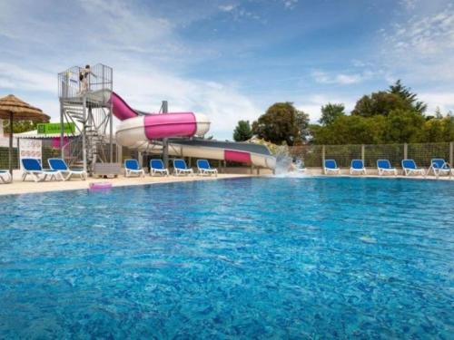 a large swimming pool with a water slide at ZEcamping 4 étoiles animé piscine couverte 1km plage fitness mobil-home TV in Saint-Jean-de-Monts
