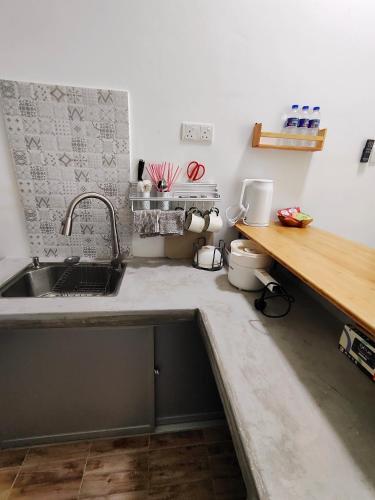 a kitchen with a sink and a wooden counter at Sunny Nest in Gopeng