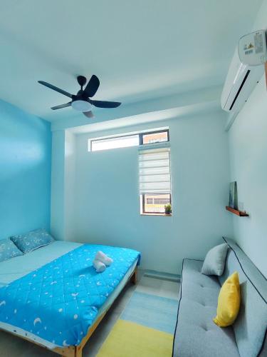a blue bedroom with a bed and a ceiling fan at Sunny Nest in Gopeng