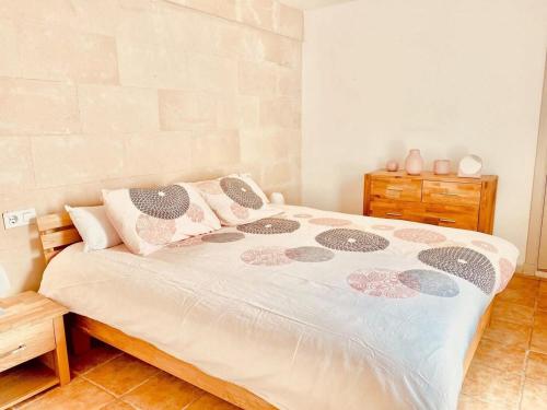 a bedroom with a large bed with pillows at Casa SONEA private access to Cala nBrut. in Cala en Blanes