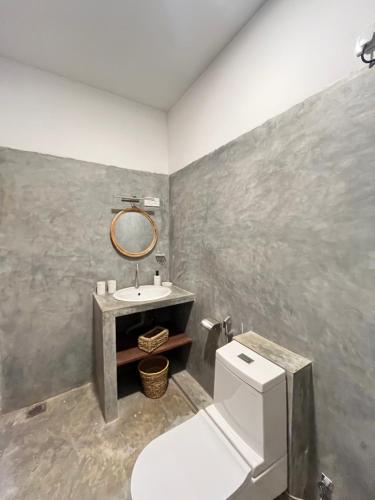 a bathroom with a toilet and a sink at La Cove in Matara