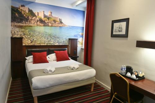 a hotel room with a bed with a painting on the wall at Hotel De L'univers in Saint Malo