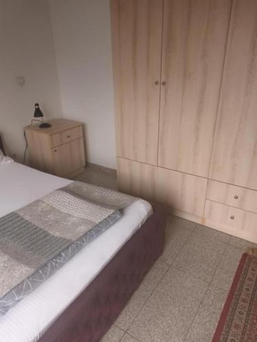 a bedroom with a bed and a wooden cabinet at Blue point in Kragujevac