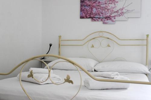 a white bed with a metal frame and white pillows at Borgo Tortorella by IL PUMO DI PUGLIA in Monopoli
