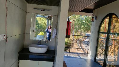a person taking a picture of a bathroom mirror at Maheshwari international in Lansdowne