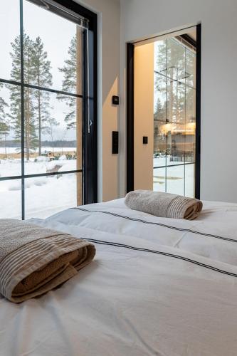 a bedroom with two beds and a large window at New Seaside Villa with Beach Sauna and Panoramic Views in Porvoo