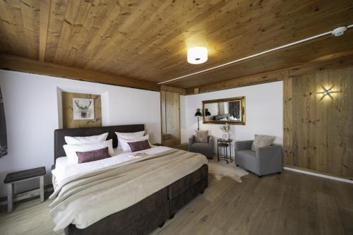 a bedroom with a large bed and a wooden ceiling at Hotel ZUM STERNENHOF in Kössen