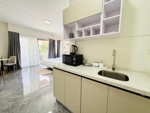 a kitchen with a sink and a bed in a room at West14 Tamarin Bay,Studio in Tamarin